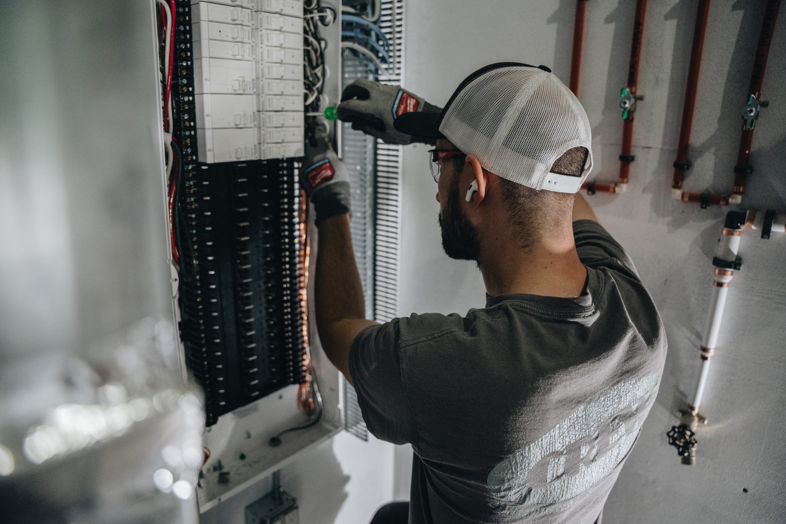 An electrician inspecting a panel to find out why a breaker is constantly tripping.