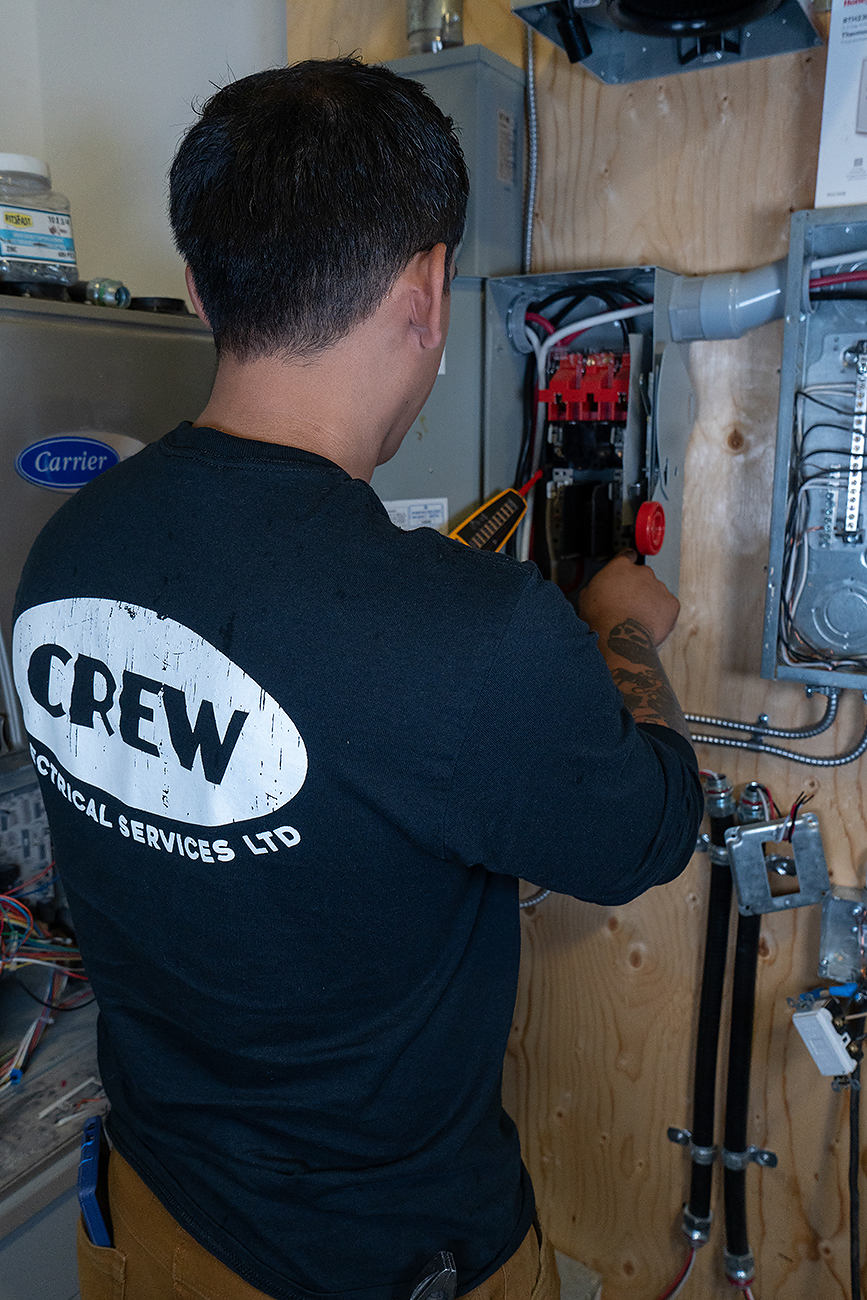 An electrician inspecting a panel to find out why a breaker is constantly tripping.