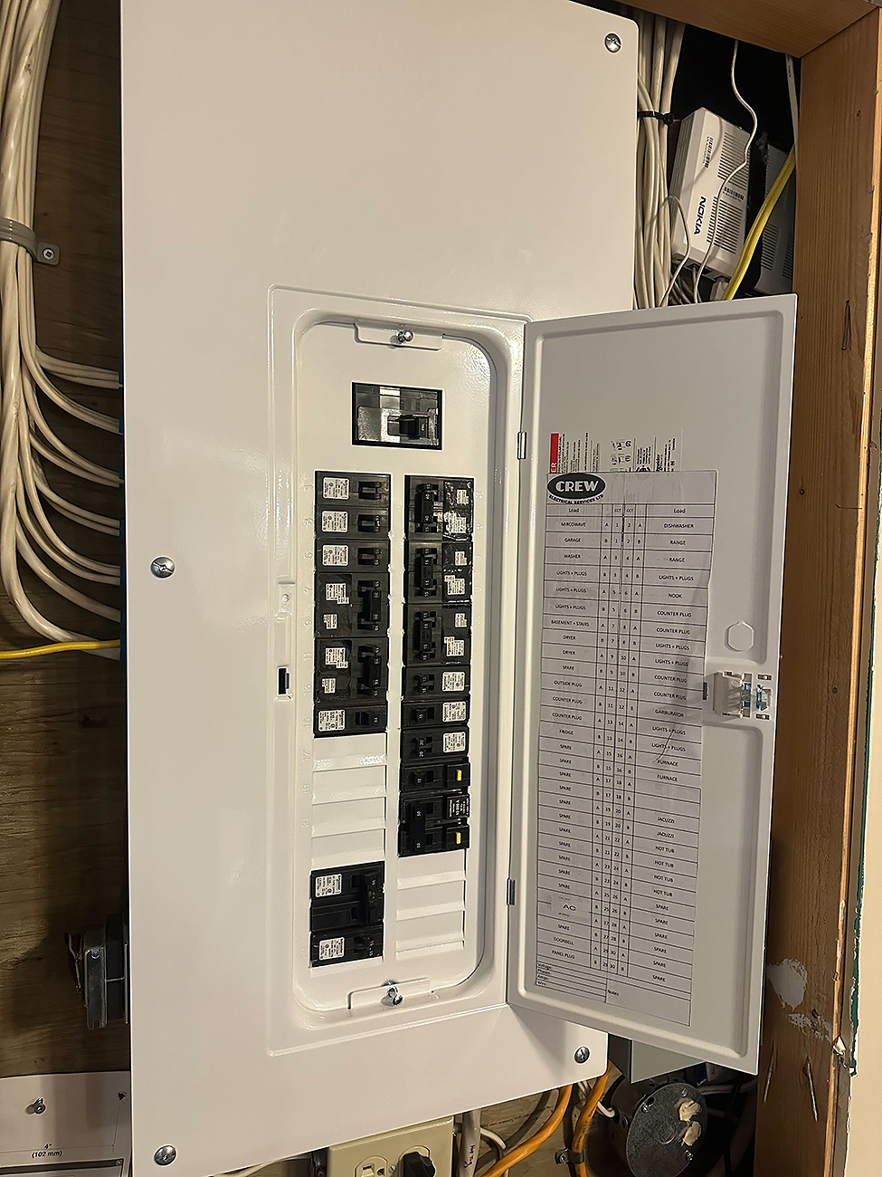 Crew Electrical Services technician setting up a residential load management system in Calgary.