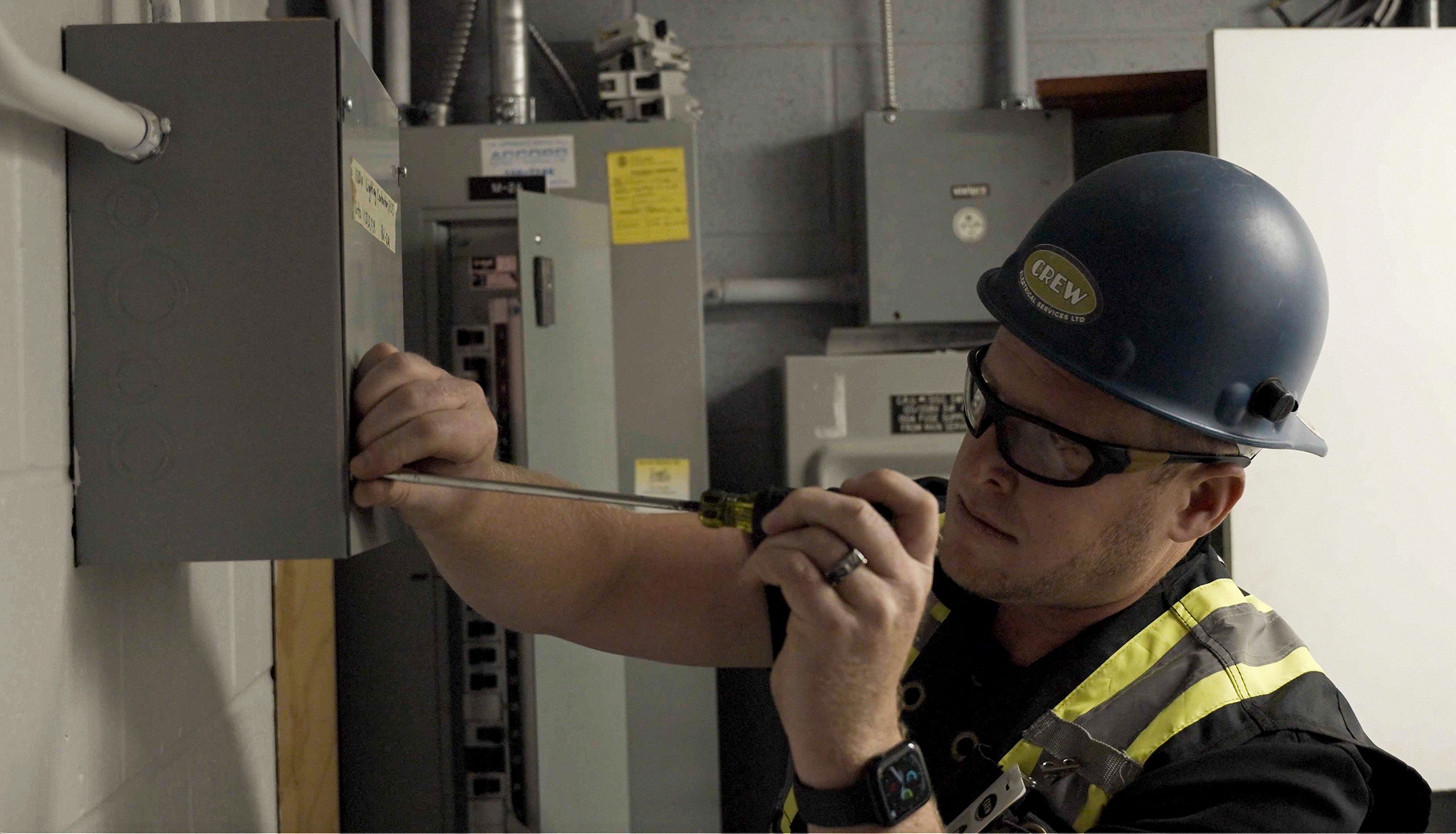 Electrician setting up cords and connections for temporary site power in Calgary